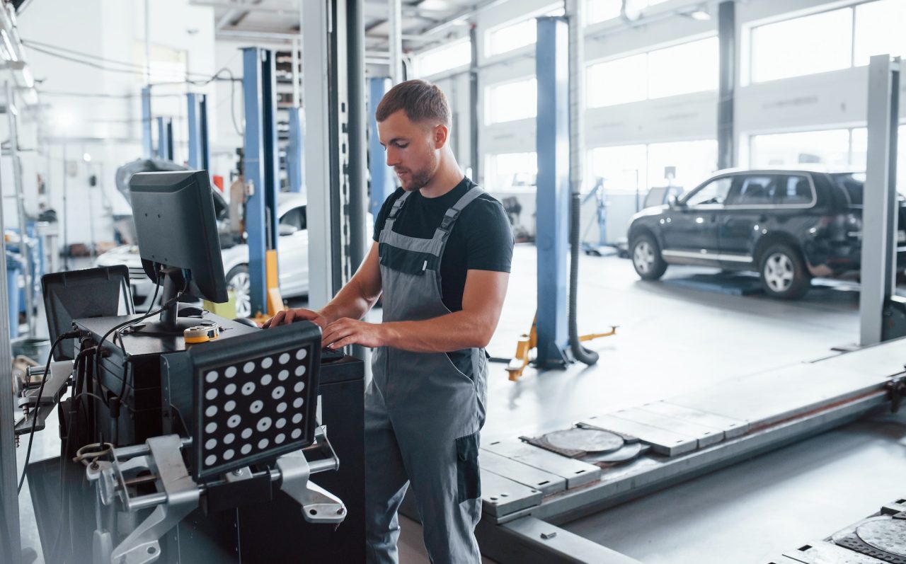 Mechanic using computer in workshop for vehicle diagnostics