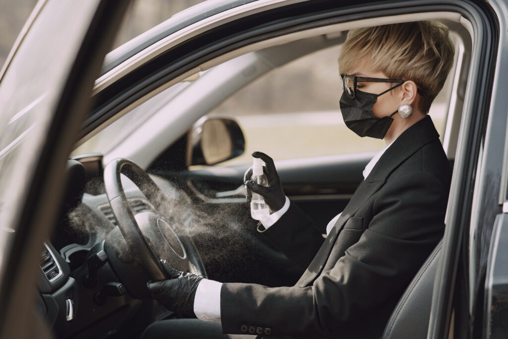 Businesswoman wearing mask sitting inside car