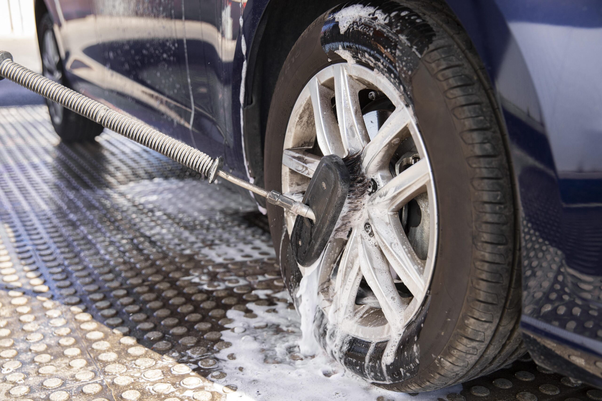 Close-up of car being washed with water and foam