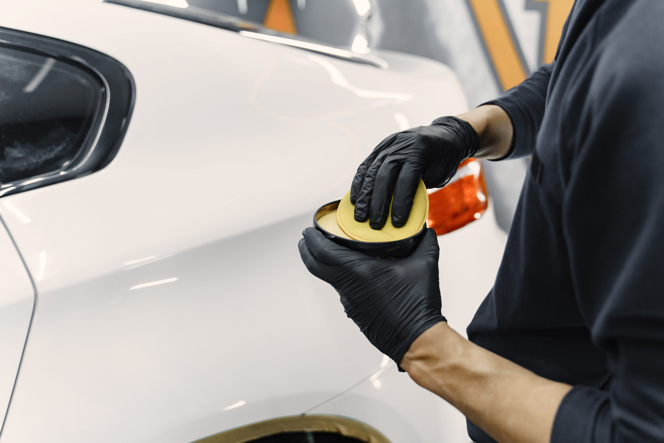Man polishing car body using professional detailing tools
