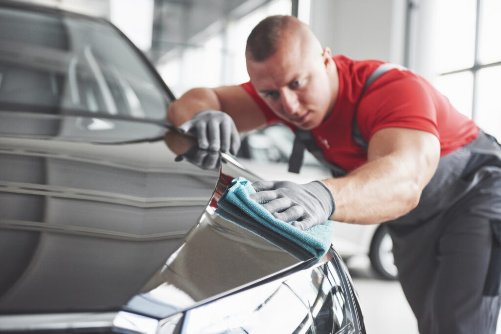 Professional car cleaning service inside auto showroom